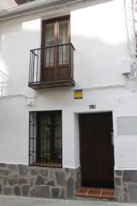a white building with two doors and a balcony at La Casita in Cenes de la Vega