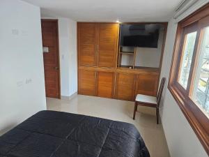 a bedroom with a bed and a tv and a chair at Guest House with AC, close to Historical Centre 3 in Cartagena de Indias