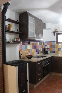 a kitchen with brown cabinets and a counter top at La Casita in Cenes de la Vega