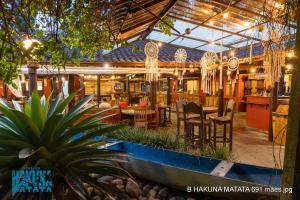 un restaurante con mesa, sillas y luces en Pousada Hakuna Matata, en Morretes