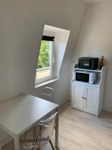 a small room with a table and a microwave at Le Jardin du Haras in Saint Lo