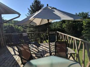 two chairs and an umbrella on a deck at Hideaway from the Twin Cities in Houlton