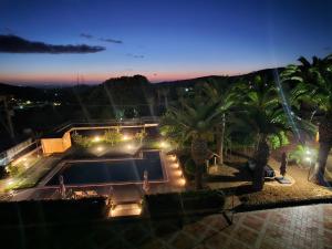 a view of a swimming pool at night with palm trees at Le Palme B&B in Salemi