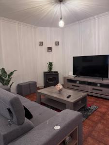 a living room with a couch and a flat screen tv at Jose s place in Alfena