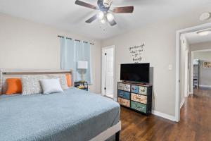a bedroom with a bed and a flat screen tv at Escape by Beaches & Blue Angels in Pensacola