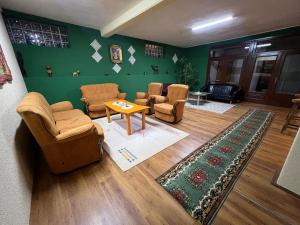 a living room with chairs and a table and a green wall at Hostel 8 in Pristina