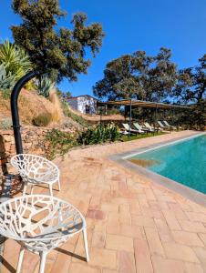 a pair of chairs sitting next to a swimming pool at Finca Bravo in Cortegana