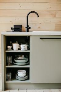 a kitchen counter with a sink and plates and dishes at Woodland Noszvaj Moha Kabin in Noszvaj +4 photos