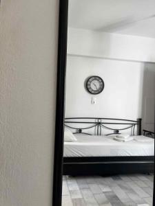 a bedroom with a bed with a clock on the wall at Studio Tsakas in Naxos Chora