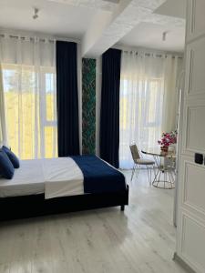 a bedroom with a bed and a table and windows at Studio Factory 22 in Braşov