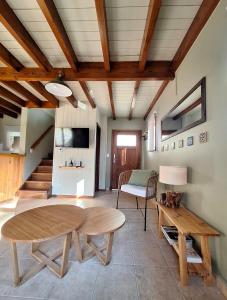 ein Wohnzimmer mit einem Holztisch und Bänken in der Unterkunft Cabaña Amancay, comodidad y tranquilidad a pasos del centro - Ayres del Bosque Alojamientos in San Martín de los Andes