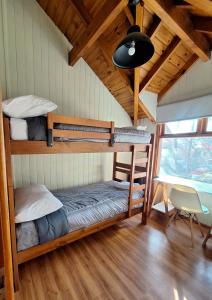 ein Schlafzimmer mit Etagenbetten in einer Hütte in der Unterkunft Cabaña Amancay, comodidad y tranquilidad a pasos del centro - Ayres del Bosque Alojamientos in San Martín de los Andes