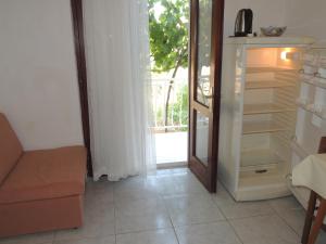a room with an open refrigerator next to a door at CROSurf Apartments Pelješac Kučište in Kučište