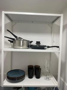 a shelf with a pot and plates and a wine glass at Casa A'Bareis in Polignano a Mare