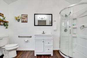 a white bathroom with a toilet and a shower at Cozy Country Living Cabin in SlidellandDecatur! in Decatur