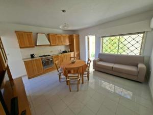 a living room with a table and a couch at Spacious Bugibba Seafront Villa Free Parking & WiFi in St. Paul's Bay