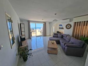 a living room with a couch and a coffee table at Spacious Bugibba Seafront Villa Free Parking & WiFi in St. Paul's Bay