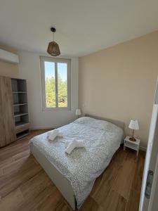 une chambre avec un lit avec deux serviettes dessus dans l'établissement Le 37 FOCH, à Orange