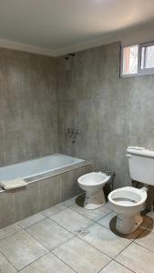 a bathroom with a toilet and a tub and a sink at Habitación privada con cama matrimonial, baño y salida al jardín in Colonia Las Rosas +5 photos