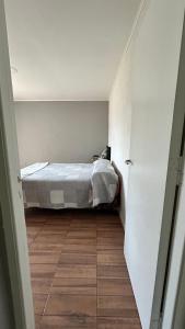 a bedroom with a bed and a wooden floor at Habitación privada con cama matrimonial, baño y salida al jardín in Colonia Las Rosas