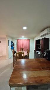 a living room with a table and a kitchen at Habitación privada con cama matrimonial, baño y salida al jardín in Colonia Las Rosas