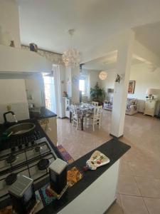 a kitchen with a stove and a living room at Skyline Appartamento Lella in Acqui Terme +19 photos