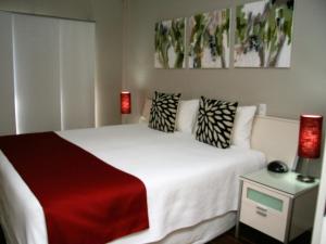 
a bed room with a white bedspread and pillows at Chaucer Palms Boutique B&B in Newcastle
