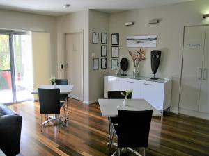 
a living room with a table and chairs at Chaucer Palms Boutique B&B in Newcastle
