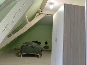ein Schlafzimmer mit einem Bett in einem Zimmer im Dachgeschoss in der Unterkunft Duplex 100m2 in Montreuil-sur-Ille
