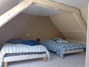 zwei Betten in einem Zimmer mit Dachboden in der Unterkunft Duplex 100m2 in Montreuil-sur-Ille