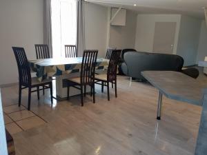 ein Esszimmer mit Tisch und Stühlen und einer Couch in der Unterkunft Duplex 100m2 in Montreuil-sur-Ille