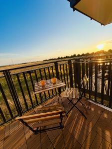 un tavolo e delle sedie su un balcone con vista sull'oceano di Apartament the world a Władysławowo