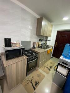 een kleine keuken met een fornuis en een magnetron bij Haven 254 Stade view Suites in Nairobi