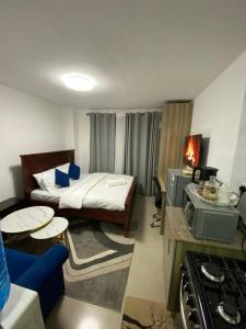 een kleine kamer met een bed en een keuken bij Haven 254 Stade view Suites in Nairobi