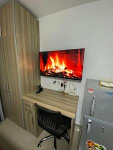 een kamer met een bureau en een open haard aan de muur bij Haven 254 Stade view Suites in Nairobi +1 foto