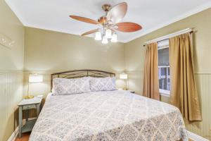 a bedroom with a bed with a ceiling fan at Oceanfront Retreat 318 Breakers in Hilton Head Island +47 photos