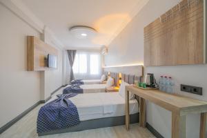 a room with two beds and a desk in it at Kar Hotel in Mersin