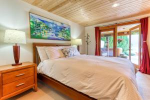 a bedroom with a bed with a wooden ceiling at Custom Built Home on the Beach in Nelson