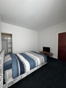 a bedroom with a bed and a television in it at Serenity Rooms in Leicester +2 photos