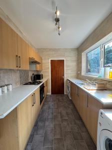 a large kitchen with wooden cabinets and a window at Serenity Rooms in Leicester