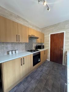 a kitchen with wooden cabinets and a stove top oven at Serenity Rooms in Leicester