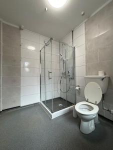 a bathroom with a toilet and a glass shower at Serenity Rooms in Leicester