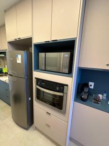 La cuisine est équipée d'un four micro-ondes et d'un réfrigérateur. dans l'établissement Flat no Paraíso da praia do Cupe - Porto de Galinhas, à Porto de Galinhas