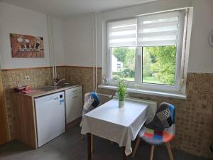 a kitchen with a table and chairs and a window at Gemütliche Wohnung mit Garten in Kehrigk