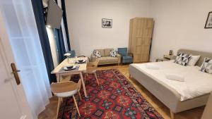 a bedroom with a bed and a table and a couch at City Park Home in Budapest
