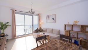 una sala de estar con un sofá y una mesa en Beautiful Sea View Apartment, en Ras al Khaimah