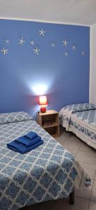 a bedroom with two beds and a blue wall with stars at Casa Vacanze Laura in Tortolì