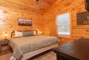 ein Schlafzimmer mit einem Bett in einer Blockhütte in der Unterkunft Relaxing cabin retreat-pool, hot tub and game room in Sevierville