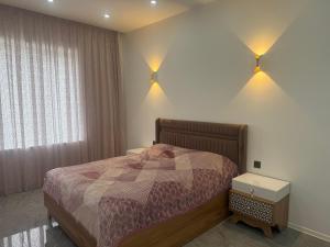 a bedroom with a bed and two lights on the wall at Melhem Twin Homes in Şamaxı