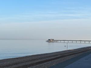 a pier in the water next to a beach at The A in Walmer